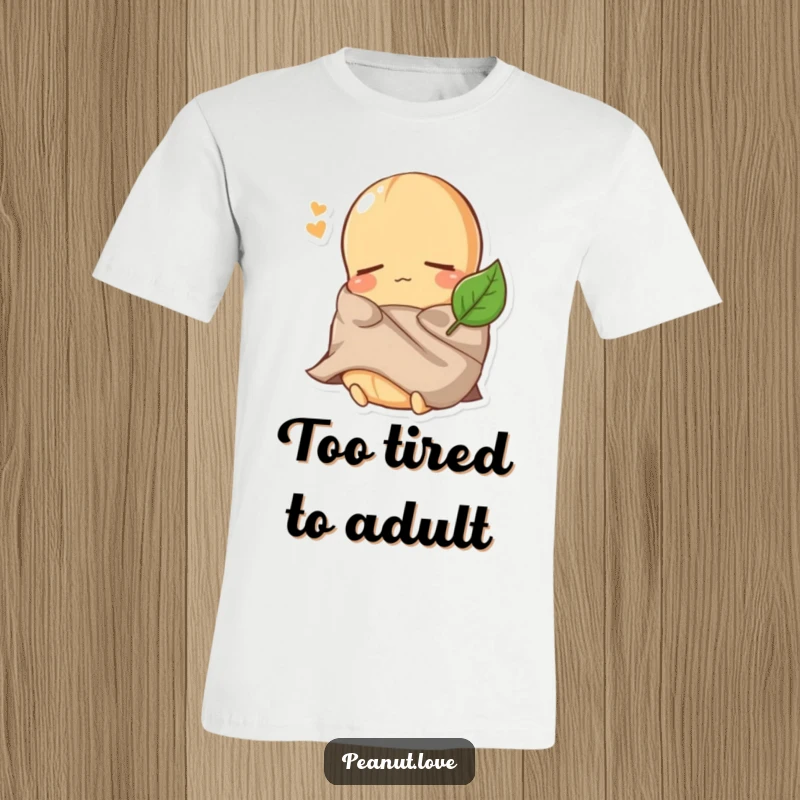 Funny Peanut T-Shirt: A comically sleepy peanut character is dressed adorably, cozying up under a tiny leaf blanket.